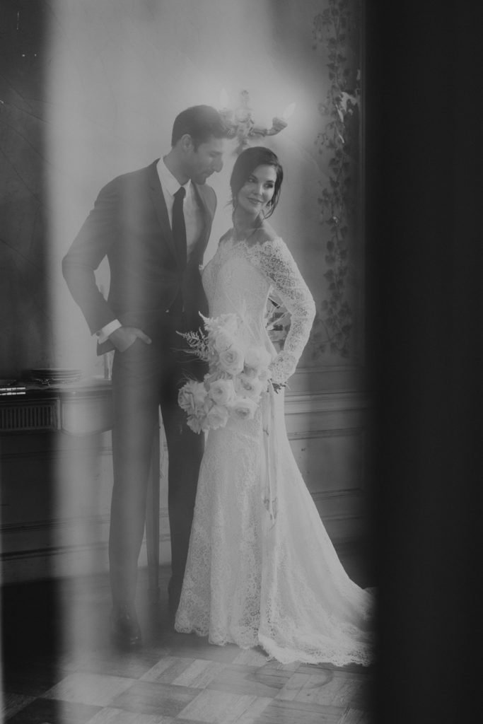 A candid black and white image of the bride and groom on their wedding day.