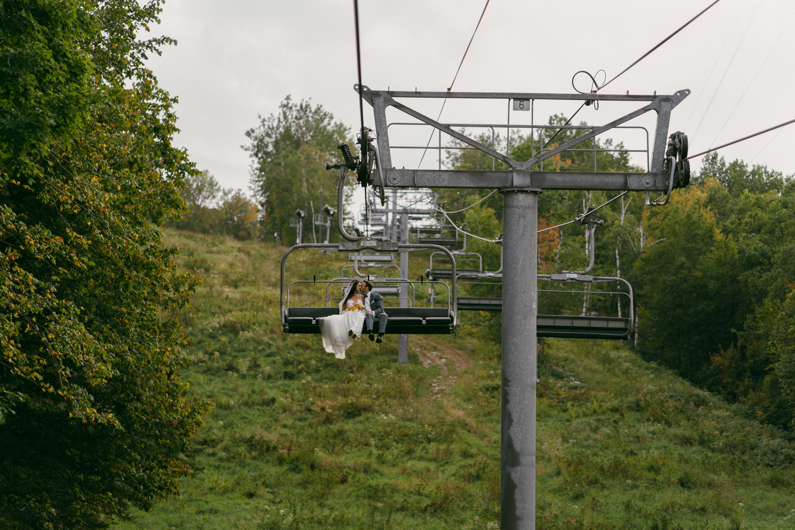 Bride and groom riding the chairlift from Rib Mountain Amphitheater ceremony to their reception at the Sundance Chalet.